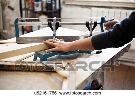 Male artist, sawing wood, making frame for artwork View Large Photo Image Stock Photograph - Male artist, sawing wood, making frame for artwork. Fotosearch