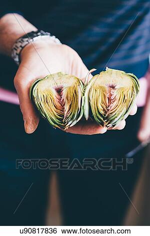 Male hands holding prepared globe artichokes halves View Large Photo Image Stock Photograph - Male hands holding prepared globe artichokes halves. Fotosearch