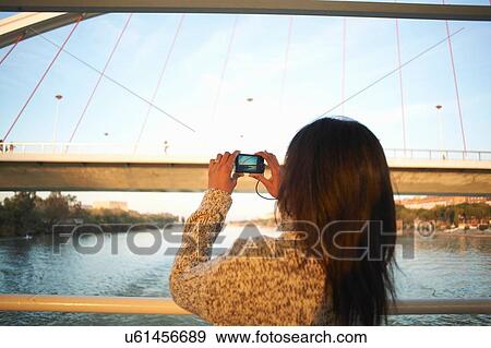 Mature female tourist photographing at Guadalqivir river on digital camera, Seville, Spain View Large Photo Image Stock Photo - Mature female tourist photographing at Guadalqivir river on digital camera, Seville, Spain. Fotosearch