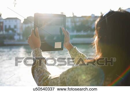 Mature female tourist photographing Guadalqivir river on digital tablet, Seville, Spain View Large Photo Image Stock Photo - Mature female tourist photographing Guadalqivir river on digital tablet, Seville, Spain. Fotosearch