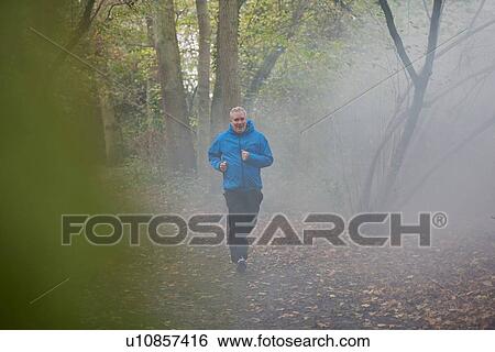 Mature male runner running through forest mist View Large Photo Image Stock Photograph - Mature male runner running through forest mist. Fotosearch
