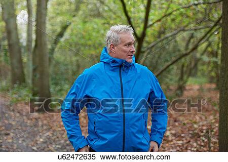 Stock Photography - Mature male runner taking a break in forest. Fotosearch