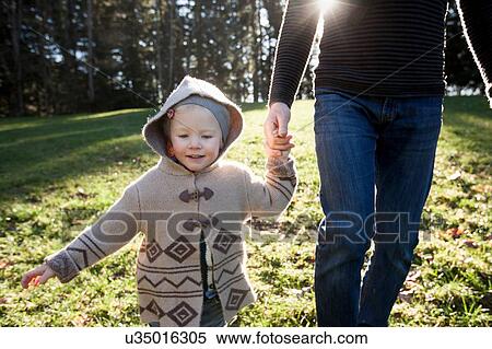 Stock Photography - Mature man and toddler daughter out walking. Fotosearch