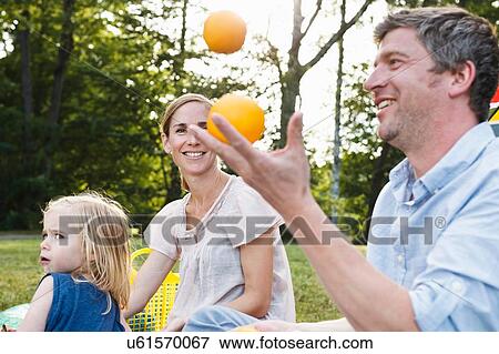 Mature man juggling oranges at family picnic in park View Large Photo Image Stock Photo - Mature man juggling oranges at family picnic in park. Fotosearch
