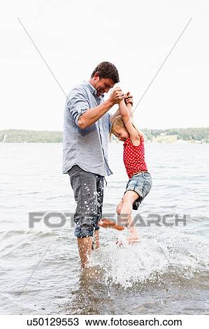 Mature man lifting up daughter from lake Starnberg, Bavaria, Germany View Large Photo Image Stock Image - Mature man lifting up daughter from lake Starnberg, Bavaria, Germany. Fotosearch