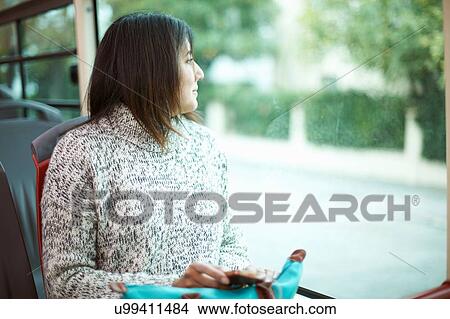 Mature woman sitting on bus, looking out of window View Large Photo Image Picture - Mature woman sitting on bus, looking out of window. Fotosearch