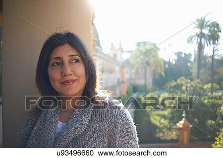 Mature woman wearing cardigan leaning against pillar looking away smiling View Large Photo Image Stock Image - Mature woman wearing cardigan leaning against pillar looking away smiling. Fotosearch