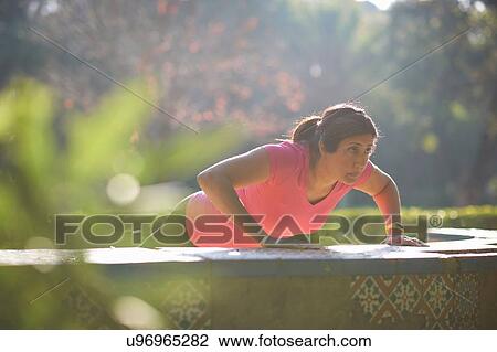 Mature woman wearing headphone doing push up on bench View Large Photo Image Stock Image - Mature woman wearing headphone doing push up on bench. Fotosearch
