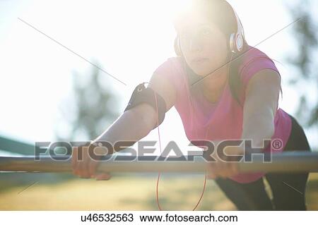 Mature woman wearing headphones doing push up using metal bar View Large Photo Image Stock Image - Mature woman wearing headphones doing push up using metal bar. Fotosearch