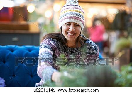 Stock Photography - Mature woman wearing knit hat drinking red wine at sidewalk cafe. Fotosearch