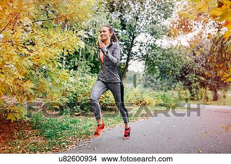 Mid adult female runner running along park path View Large Photo Image Picture - Mid adult female runner running along park path. Fotosearch