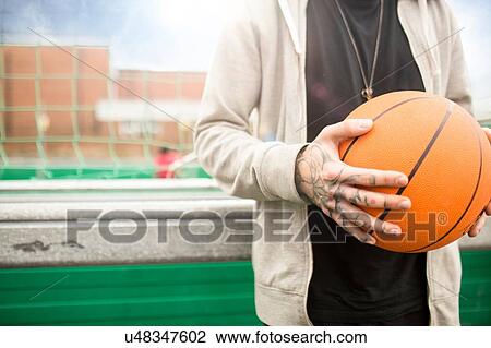 Mid adult man holding basketball, mid section View Large Photo Image Stock Image - Mid adult man holding basketball, mid section. Fotosearch