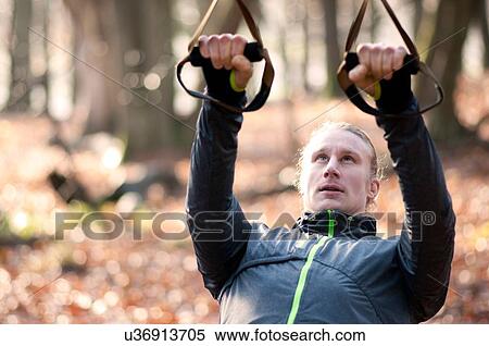 Mid adult man using resistance bands, looking up View Large Photo Image Stock Photography - Mid adult man using resistance bands, looking up. Fotosearch