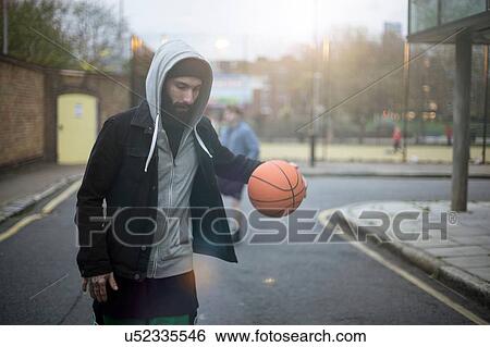 Mid adult man walking along street, bouncing basketball View Large Photo Image Stock Photograph - Mid adult man walking along street, bouncing basketball. Fotosearch