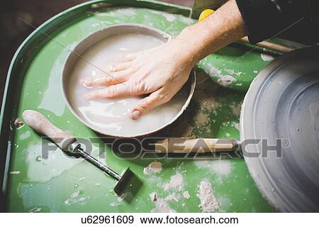 Mid adult mans hand immersed in bowl of water on pottery wheel View Large Photo Image Stock Photo - Mid adult mans hand immersed in bowl of water on pottery wheel. Fotosearch