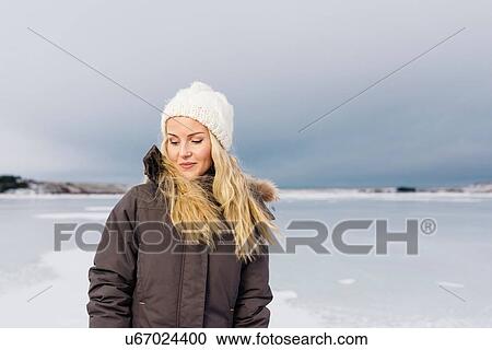 Mid adult woman by frozen lake looking down smiling View Large Photo Image Stock Image - Mid adult woman by frozen lake looking down smiling. Fotosearch