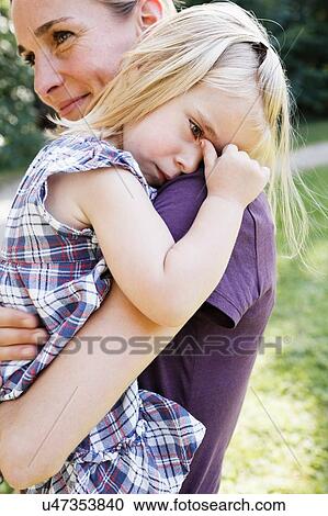 Mid adult woman carrying upset daughter in park View Large Photo Image Stock Image - Mid adult woman carrying upset daughter in park. Fotosearch