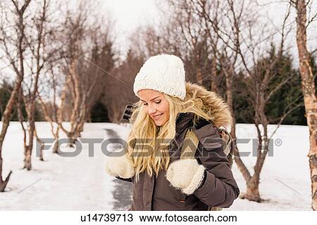 Mid adult woman on snow covered tree lined pathway looking down smiling View Large Photo Image Stock Image - Mid adult woman on snow covered tree lined pathway looking down smiling. Fotosearch
