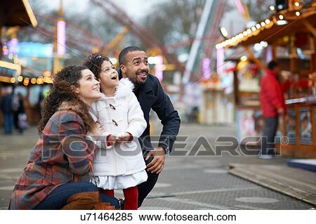 Stock Photography - Mother and daughter in amusement park looking up smiling. Fotosearch