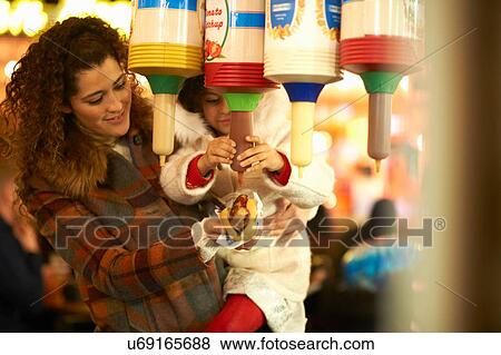 Stock Photo - Mother and daughter squeezing tomato ketchup onto hotdog. Fotosearch