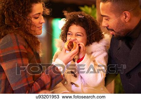 Mother and father feeding daughter hot dog View Large Photo Image Stock Image - Mother and father feeding daughter hot dog. Fotosearch