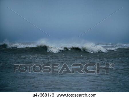 Stock Image - Ocean waves at dusk. Fotosearch