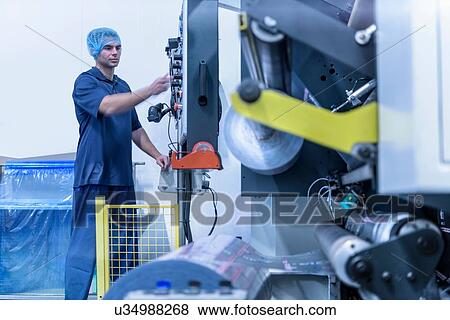 Operator and printing machine in food packaging printing factory View Large Photo Image Stock Photo - Operator and printing machine in food packaging printing factory. Fotosearch