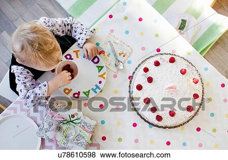 Overhead view of female toddler eating raspberries at birthday tea party table View Large Photo Image Stock Photo - Overhead view of female toddler eating raspberries at birthday tea party table. Fotosearch