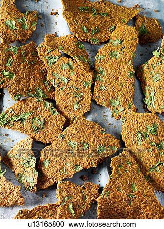 Stock Image - Overhead view of homemade coriander and chilli chips. Fotosearch