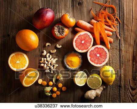 Overhead view of orange fruit and vegetables on wood grain pattern background View Large Photo Image Stock Photo - Overhead view of orange fruit and vegetables on wood grain pattern background. Fotosearch