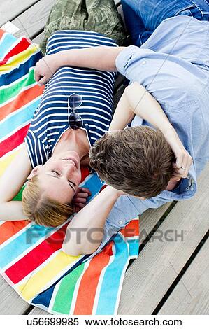 Overhead view of romantic couple sitting on wooden pier View Large Photo Image Stock Photography - Overhead view of romantic couple sitting on wooden pier. Fotosearch