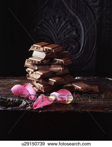 Pink rose petals and broken chocolate bars stacked on wooden cutting board View Large Photo Image Stock Photo - Pink rose petals and broken chocolate bars stacked on wooden cutting board. Fotosearch