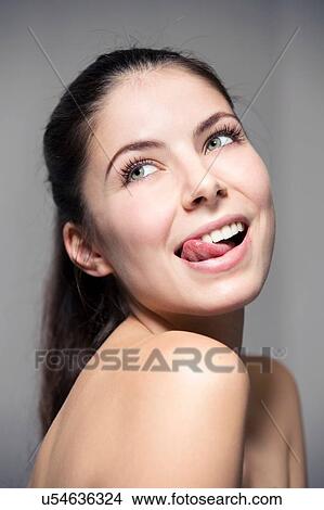 Portrait of bare shoulder young woman sticking out tongue View Large Photo Image Picture - Portrait of bare shoulder young woman sticking out tongue. Fotosearch