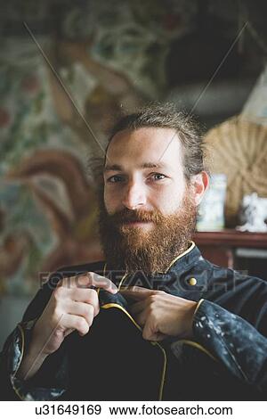 Portrait of bearded mid adult man buttoning up clay covered jacket, looking at camera smiling View Large Photo Image Stock Photo - Portrait of bearded mid adult man buttoning up clay covered jacket, looking at camera smiling. Fotosearch
