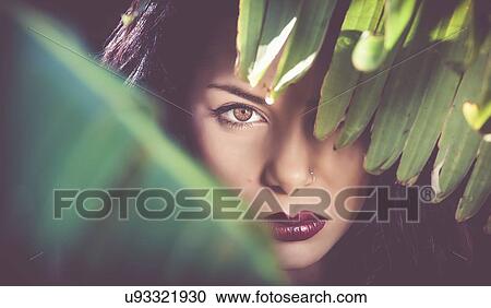 Portrait of beautiful sultry young woman behind leaves at night View Large Photo Image Stock Image - Portrait of beautiful sultry young woman behind leaves at night. Fotosearch