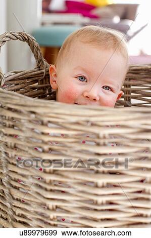 Portrait of cute female toddler hiding in wicker basket View Large Photo Image Stock Photo - Portrait of cute female toddler hiding in wicker basket. Fotosearch