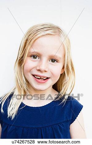 Stock Photo - Portrait of cute girl with toothy grin in front of white wall. Fotosearch