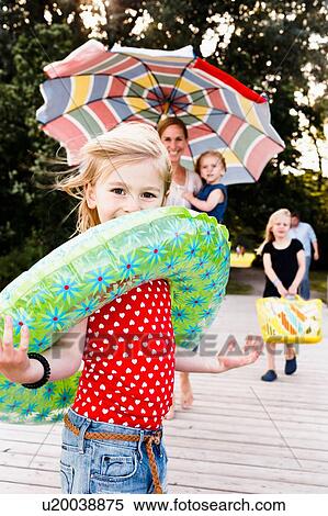 Portrait of family and cute girl playing with inflatable ring on pier at lake Starnberg, Bavaria, Germany View Large Photo Image Stock Photography - Portrait of family and cute girl playing with inflatable ring on pier at lake Starnberg, Bavaria, Germany. Fotosearch