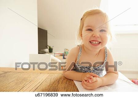 Stock Photo - Portrait of female toddler drawing at table. Fotosearch