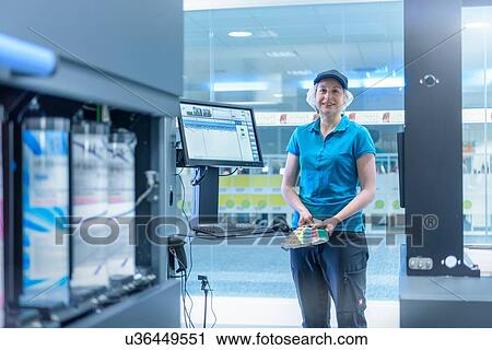 Stock Image - Portrait of female worker in food packaging printing factory. Fotosearch