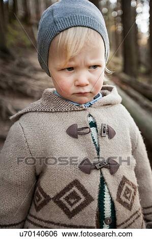 Portrait of frowning female toddler wearing knit hat in forest View Large Photo Image Stock Photograph - Portrait of frowning female toddler wearing knit hat in forest. Fotosearch