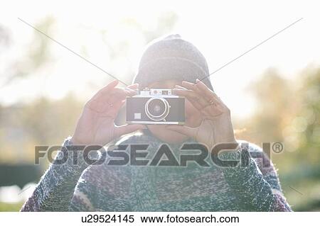 Portrait of mature woman photographing with SLR camera in sunlit park View Large Photo Image Stock Photography - Portrait of mature woman photographing with SLR camera in sunlit park. Fotosearch