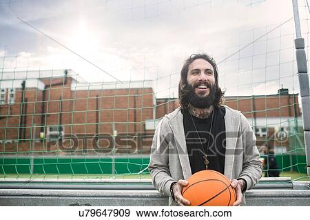 Portrait of mid adult man holding basketball View Large Photo Image Stock Photo - Portrait of mid adult man holding basketball. Fotosearch