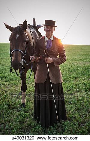 Portrait of woman standing with dressage horse in field View Large Photo Image Stock Image - Portrait of woman standing with dressage horse in field. Fotosearch