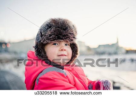 Portrait of young girl wearing red anorak and fur trapper hat looking over her shoulder in snow, Reykjavik, Iceland View Large Photo Image Stock Photo - Portrait of young girl wearing red anorak and fur trapper hat looking over her shoulder in snow, Reykjavik, Iceland. Fotosearch