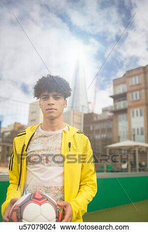 Picture - Portrait of young man holding football. Fotosearch