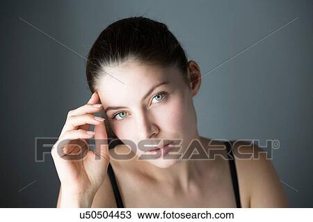Portrait of young woman hand on forehead looking at camera View Large Photo Image Stock Image - Portrait of young woman hand on forehead looking at camera. Fotosearch