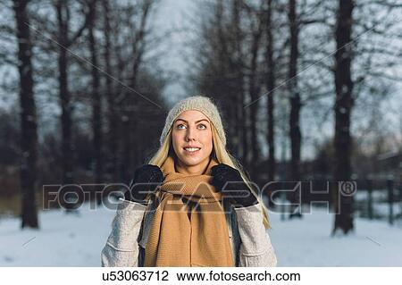 Portrait of young woman in snow wearing woollen hat and scarf looking up smiling View Large Photo Image Stock Image - Portrait of young woman in snow wearing woollen hat and scarf looking up smiling. Fotosearch