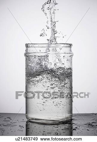 Pouring water into glass container View Large Photo Image Stock Photo - Pouring water into glass container. Fotosearch
