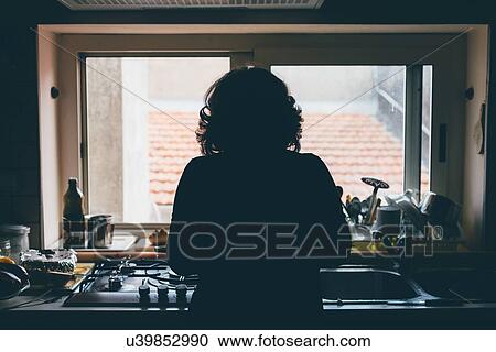 Rear silhouetted view of woman standing in front of kitchen sink View Large Photo Image Stock Image - Rear silhouetted view of woman standing in front of kitchen sink. Fotosearch